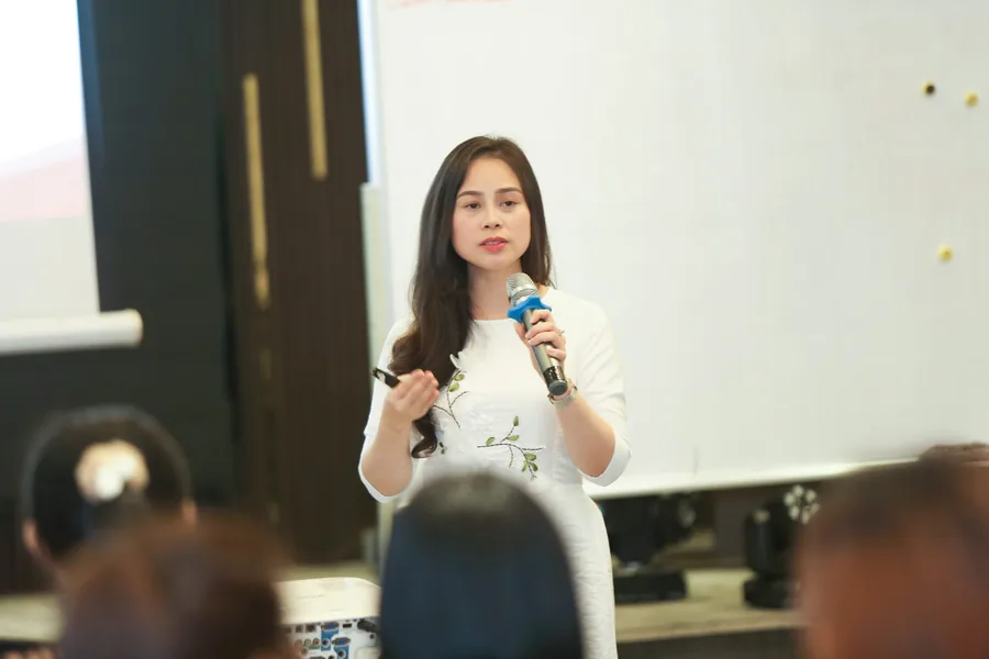Nguyễn Tú Oanh cầm micro giảng trước lớp Làm Chủ Cảm Xúc